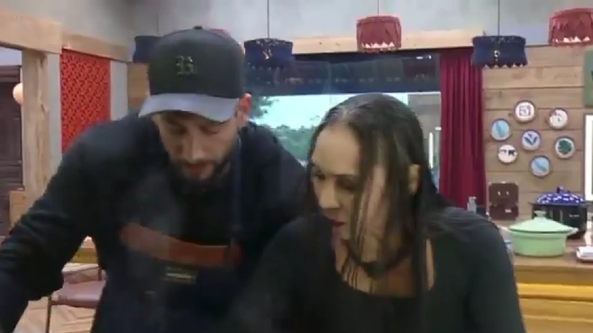 Yoná tenta pegar bife e Nizam tira a panela para impedir