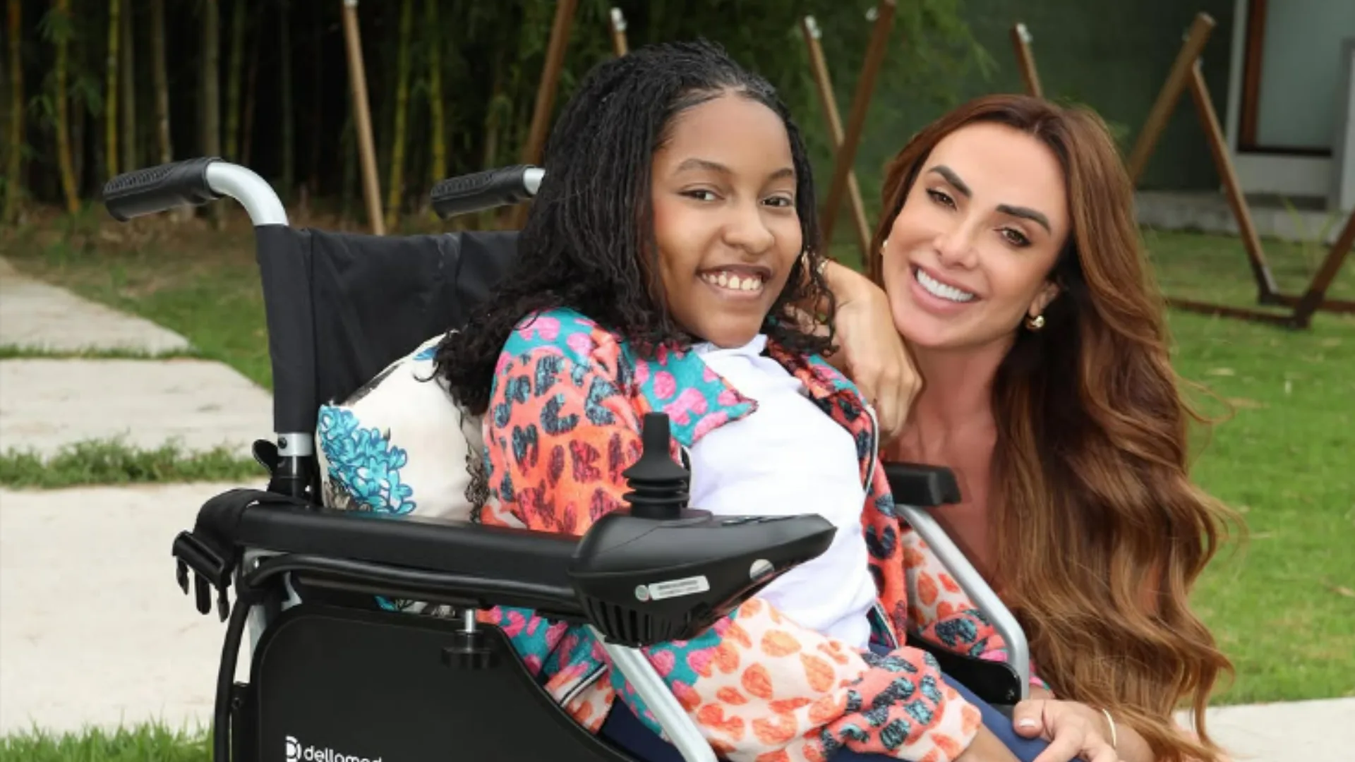 Nicole Bahls presenteia jovem com cadeira de rodas motorizada